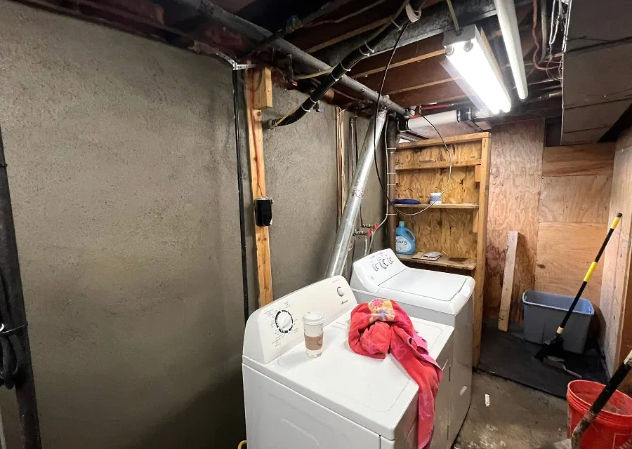 A basement wall and floor prepared for drainage and moisture control